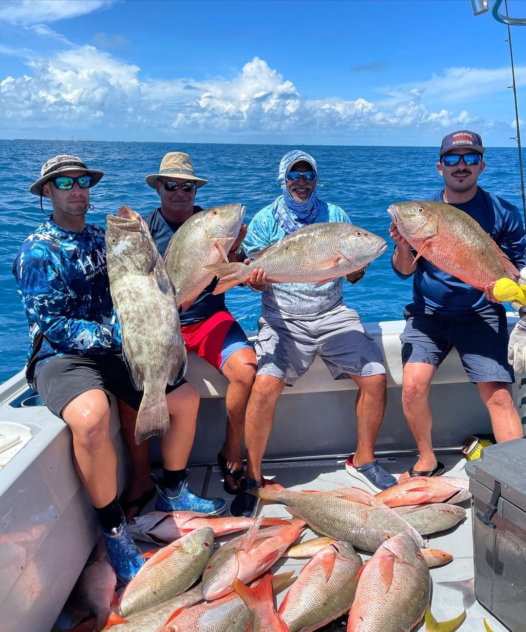 A group of anglers proudly displaying their large catch of fish on a boat, highlighting a successful "Sugarloaf Key Fishing" adventure with Fish Daily Charters.